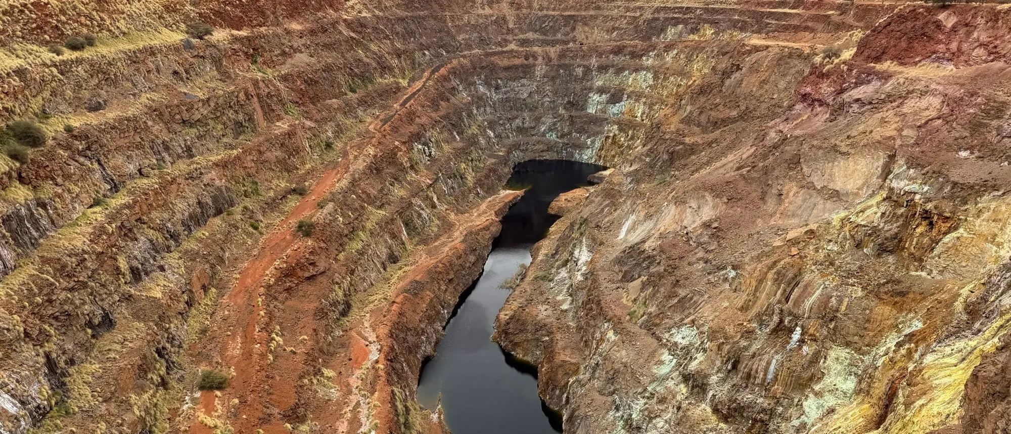 Benched walls of the former open pit with water at its base